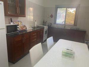 a kitchen with a white table with acomputeropter on it at Ponta do Ouro - MJ Residence in Ponta do Ouro