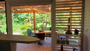 un patio con mesa de madera, sillas y mesa. en Blue lagoon - private access to blue lagoon, en Punaauia