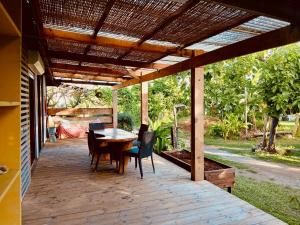 un patio con mesa y sillas bajo una pérgola en Blue lagoon - private access to blue lagoon, en Punaauia