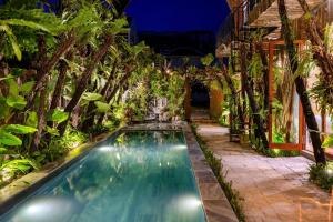 a swimming pool in a garden with trees at Timy House Villa - Tropical, Hoi An in Hoi An