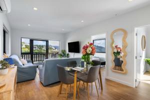 a living room with a couch and a table with a mirror at Oceanview Oasis - Home & Apartment in Tairua