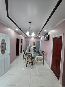 LelydorpにあるKALIKA's Appartementのピンクの壁のダイニングルーム(テーブル、椅子付)