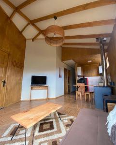 a living room with a wooden table and a couch at Siempre Verde in Puerto Tranquilo