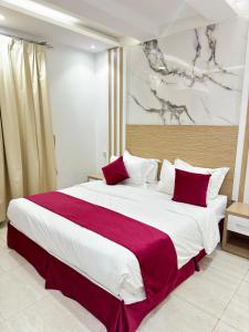a bedroom with a large bed with red and white pillows at راحتي بارك in Hafr Al Baten