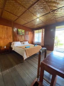 a bedroom with a bed and a table in it at Siuri Cottages & Restaurant in Tokaimbu +23 photos