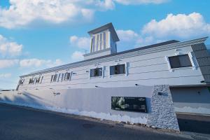 a white building with a tower on top of it at ホテルメイフェア Adult Only 男塾ホテルグループ in Yōkaichi