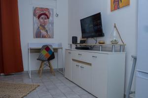 a room with a desk with a television and a painting at Kaz'Almaric - résidence calme à Rémire, proche plage et commerce in Rémiré