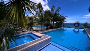 a large swimming pool with a view of the ocean at Critter Republic Dive Resort in Dauin