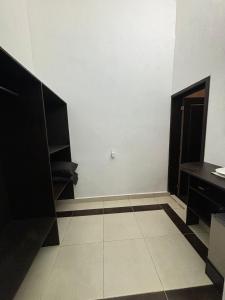 a room with a white wall and a black door at AlcBalam Room in Bacalar