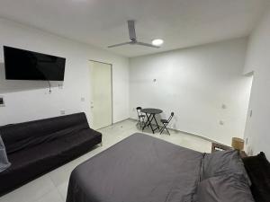 a living room with a couch and a flat screen tv at AlcBalam Room in Bacalar