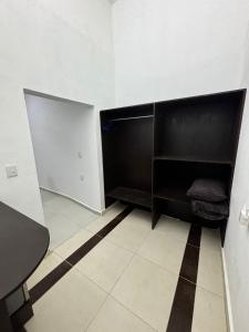 an empty room with black shelves and a table at AlcBalam Room in Bacalar