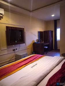 a bedroom with a large bed and a flat screen tv at Helin Terrace Hotel in Mama
