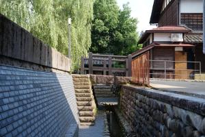 a stone retaining wall next to a house at Irifune in Katsuyama