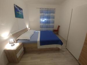 a small bedroom with a bed and a chair at Four Bedroom Holiday Home With Terrace & Sea View in Poljica