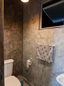 a bathroom with a toilet and a sink and a towel at Sítio Bela Vista in Angra dos Reis +73 photos