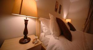 a bedroom with a bed with a lamp and pillows at Z alal Hotel in Jeddah