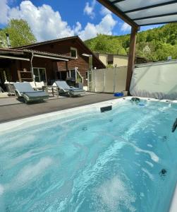 a swimming pool with blue water in front of a house at Cozy Swiss Retreat - Scenic Swiss Villa Close to Bern & Interlaken in Frinvillier