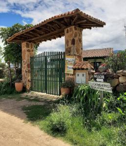 a gate with a sign in front of a fence at POSADA VILLA DEL ROSARiO in Sutamarchán