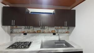 a kitchen with a sink and a stove at HOSTAL RANCHO JOTA Murillo Tolima in Murillo