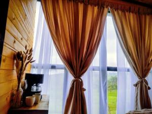 a window with a curtain in a room with at Cabaña Romántica con jacuzzi privado in Icononzo