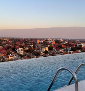 a swimming pool with a view of a city at Central apartment in Asunción in Asuncion