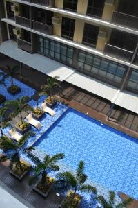 Una vista aérea de una gran piscina con palmeras. en Gentry Manor Balcony fast WIFI Okada complex near Airport&MOA 12B, en Manila