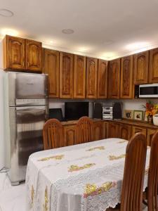 a kitchen with a table and a refrigerator and cabinets at Beautiful House - COP30 in Belém