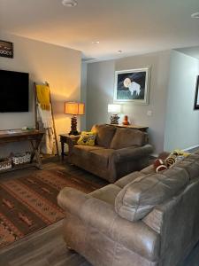 a living room with two couches and a flat screen tv at Your Honey Bee! Beautiful 2k sf! in Stillwater