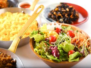 a salad in a wooden bowl on a table with other foods at Hotel Plaza Kobe in Kobe +89 photos