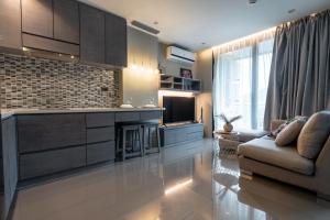 a living room with a couch and a kitchen at Suite Celeste 1BR Sunset RooftopCitygate Kamala in Kamala Beach