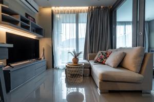 a living room with a couch and a flat screen tv at Suite Celeste 1BR Sunset RooftopCitygate Kamala in Kamala Beach