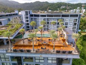 an aerial view of a building with a pool and palm trees at Suite Celeste 1BR Sunset RooftopCitygate Kamala in Kamala Beach