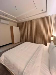a bedroom with a large white bed in a room at شقة بتصميم انيق ودخول ذاتي ج in Quai +4 photos