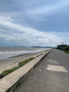 an empty road next to a beach with the ocean at Danh Tài Homestay in Kon Rung (1)