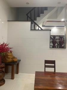 a dining room with a table and a staircase at Danh Tài Homestay in Kon Rung (1)