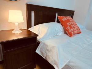 a bedroom with a bed with a night stand and a lamp at Rest Collection SEIWA LODGE Tokyo in Tokyo