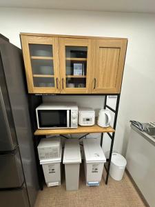a cabinet with a microwave and other appliances on it at Rest Collection SEIWA LODGE Tokyo in Tokyo +10 photos