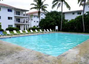 a large swimming pool with chairs and a building at Your ideal getaway awaits! in Punta Cana
