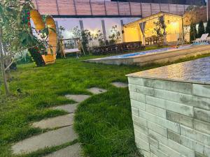 a backyard with a swimming pool and a grass yard at Qafqaz Mountside Chalet in Gabala +62 photos