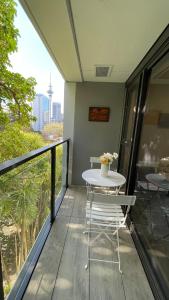 a table and chairs on a balcony with a view at Modern apartment in the city center in Auckland