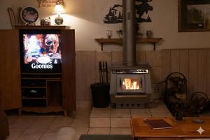 a living room with a fireplace and a television at A-Frame Cabin in The Sequoias in Wofford Heights