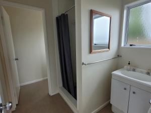 a bathroom with a shower and a sink and a mirror at Levin TOP 10 Holiday Park in Levin +72 photos