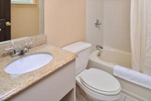 a bathroom with a sink and a toilet and a tub at Golden Hill Inn-Danbury in Danbury