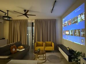 a living room with a couch and a large tv at MountAustin Projector 3BR 8pax NEW in Johor Bahru