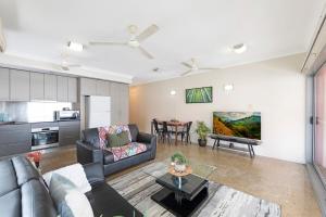 un soggiorno con un divano e un tavolo di Zen City-Venture with Balcony Dining - Cozy - CBD a Darwin