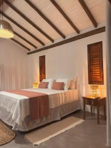 a bedroom with a large bed with pillows on it at Pousada Porto Caraíva in Caraíva