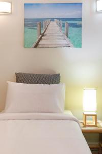 una camera con letto e molo in legno di Zen City-Venture with Balcony Dining - Cozy - CBD a Darwin