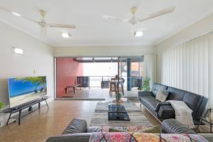 un soggiorno con un divano e una TV di Zen City-Venture with Balcony Dining - Cozy - CBD a Darwin
