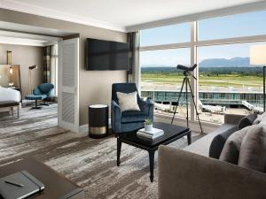 a living room with a couch and a view of an airport at Fairmont Vancouver Airport In-Terminal Hotel in Richmond