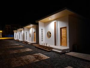 a row of white buildings at night at บีริช รีสอร์ท in Ban Pet